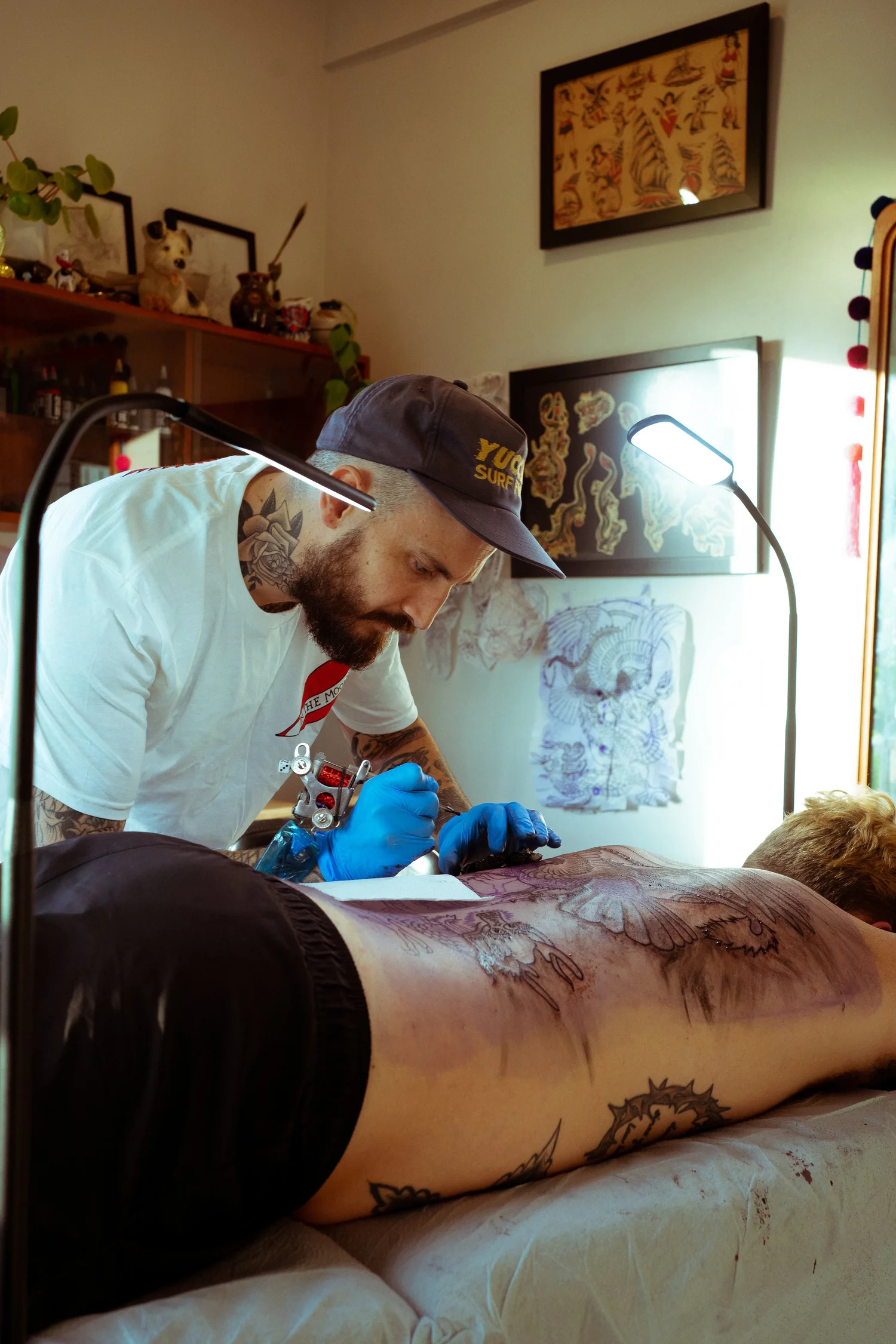 Artist working on illustrative back piece at In The Moon